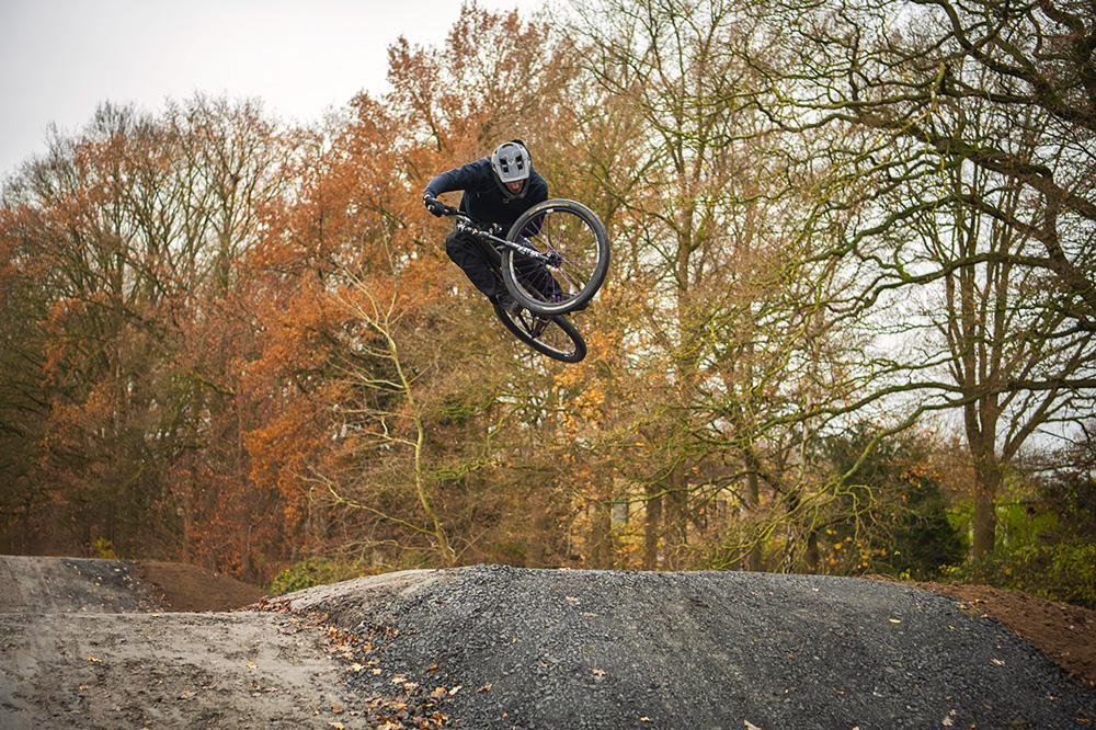 Mountainbiker fährt auf der neuen Dirtbike-Strecke und springt von einem Hügel