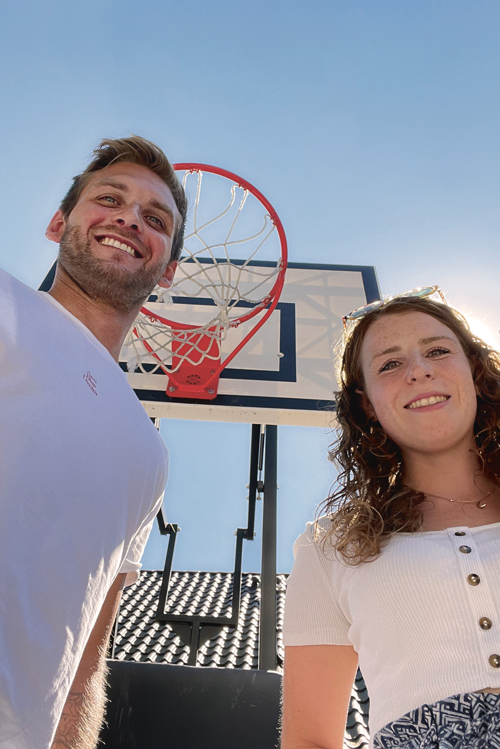 Das Bild zeigt einen Mann und eine Frau vor einem Basketballkorb.