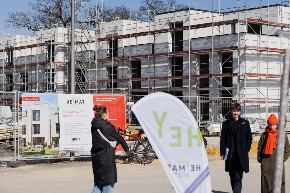 Besucher vor einem Rohbau