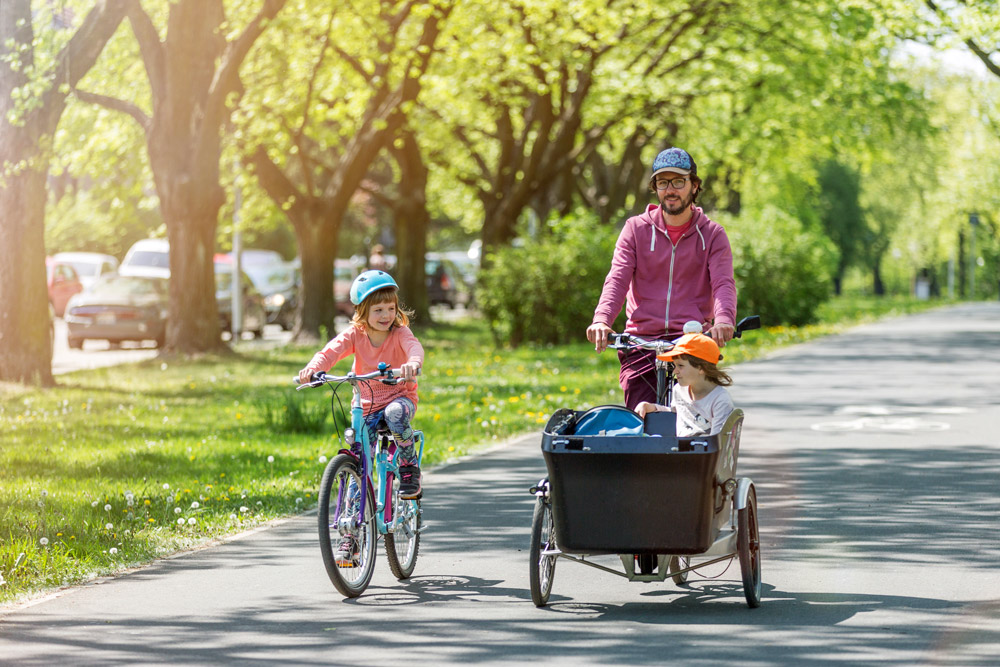 Vater fährt mit Kindern Fahrrad